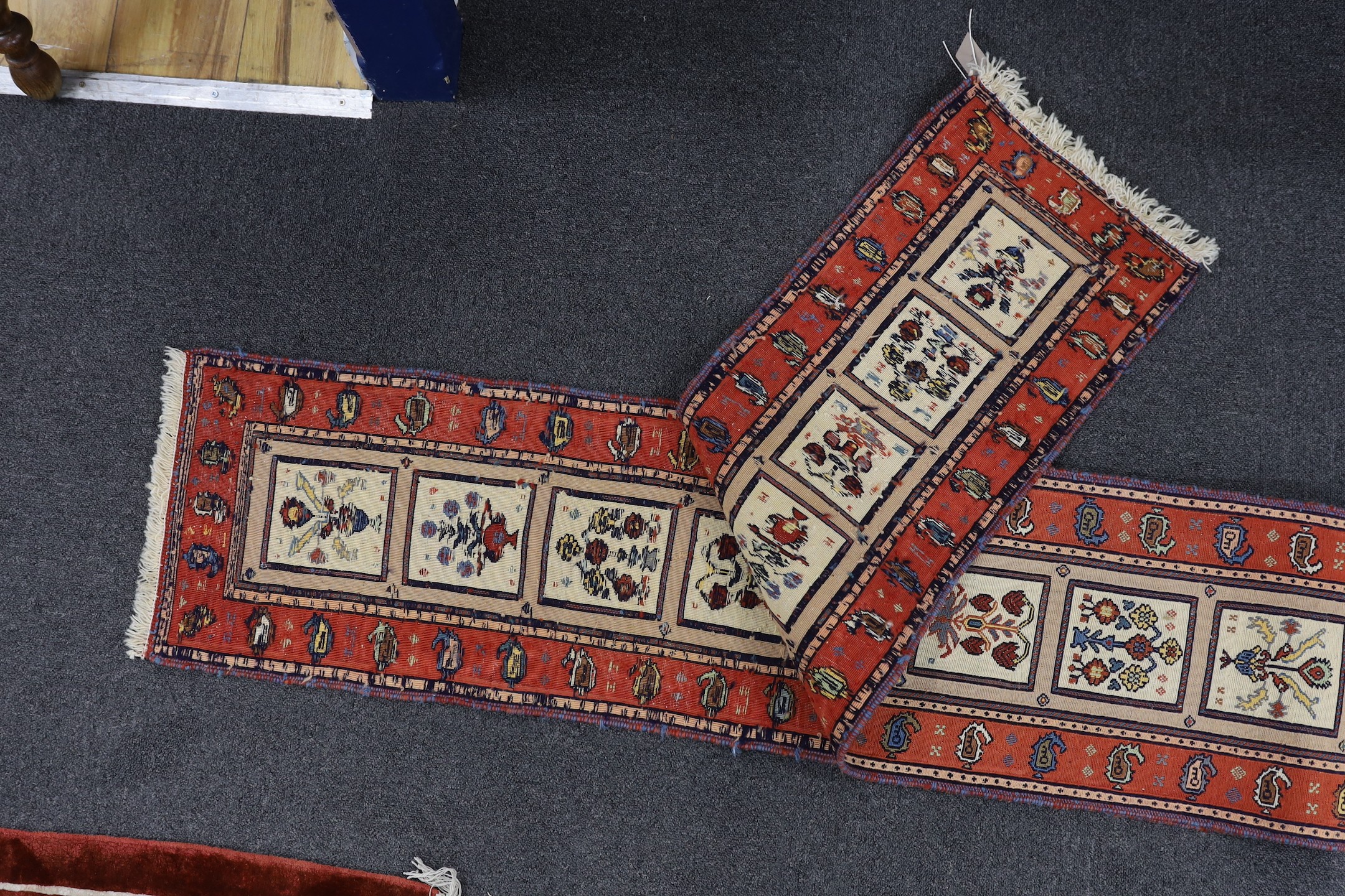 A Caucasian design red ground runner, approximately 250 x 35cm